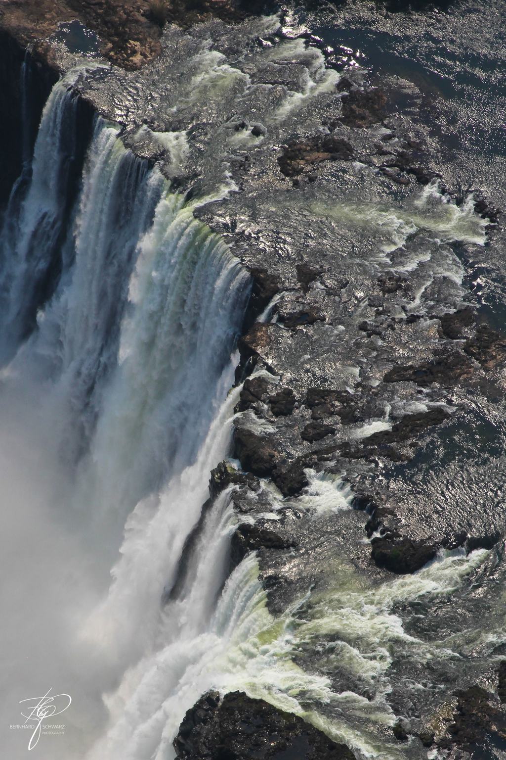 Luftbild eines Wasserfalls, der über eine Felskante in die Schlucht stürzt