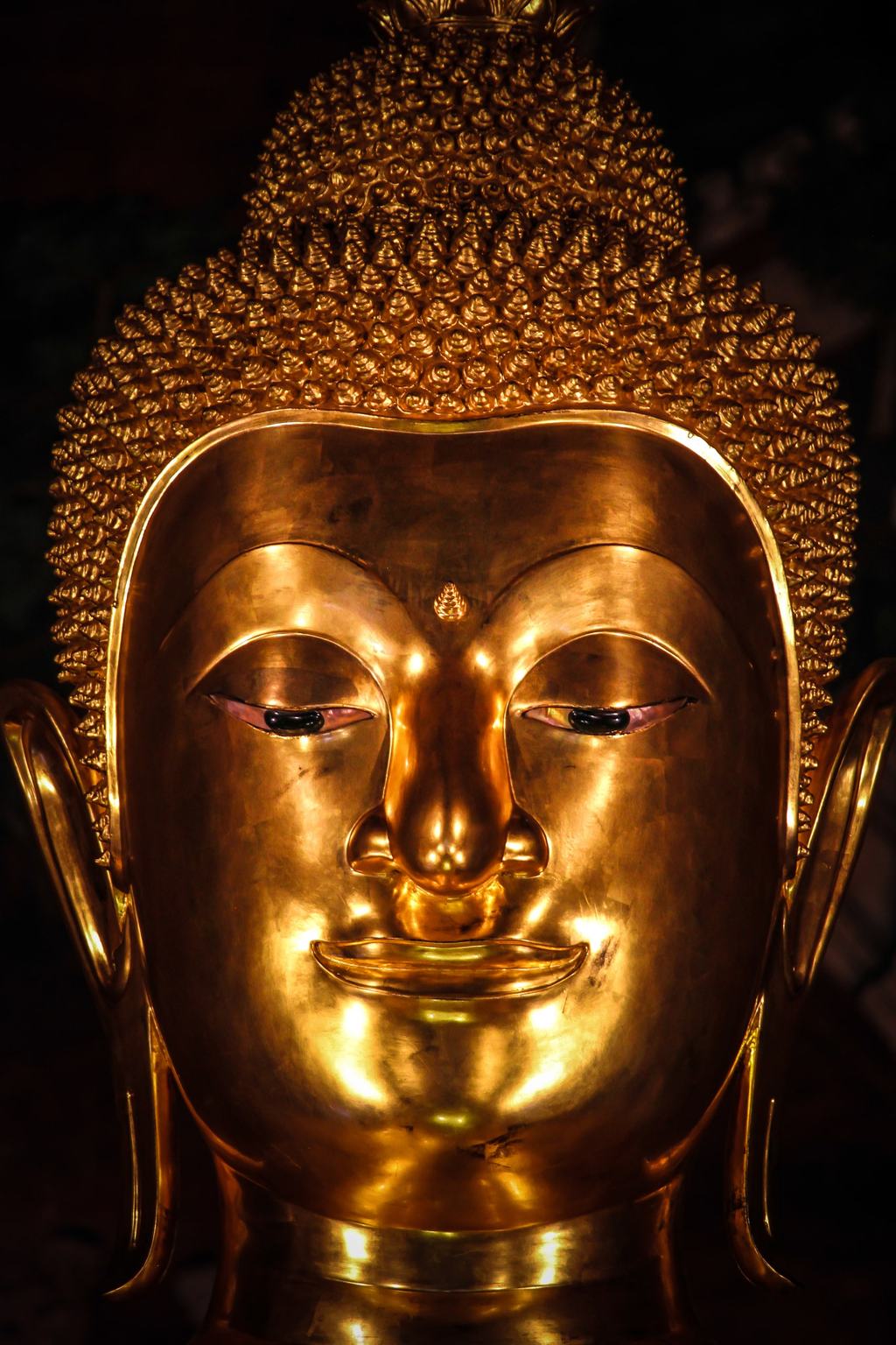 Das goldene Gesicht einer Buddha-Statue in Nahaufnahme